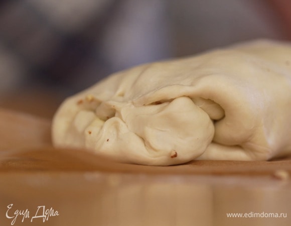 Посыпать все сахаром, свернуть тесто в рулет по длинной стороне и, не снимая его с бумаги для выпечки, скрепить концы.