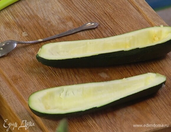Цукини разрезать пополам вдоль и ложкой вынуть мякоть, не прорезая кожуру.
