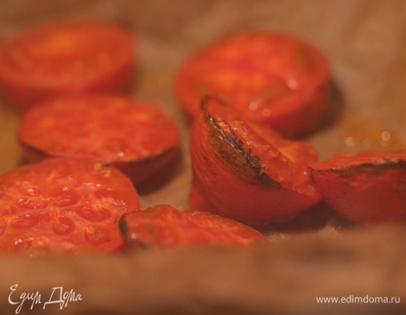 Помидоры разрезать пополам, выложить в небольшой противень, выстеленный бумагой для выпечки, и запекать под разогретым грилем, так чтобы они хорошо подрумянились.