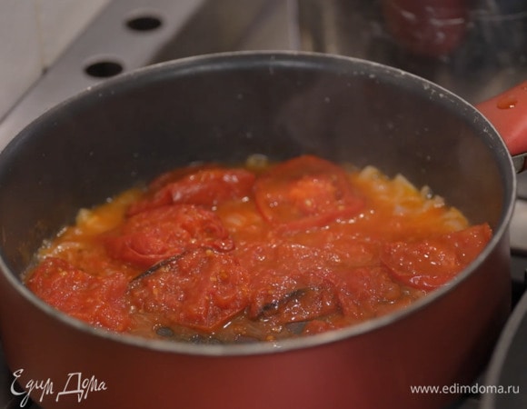 Разогреть в тяжелом сотейнике 1 ст. ложку сливочного и оливковое масло, и обжарить лук и чеснок до прозрачности, затем добавить запеченные помидоры вместе с выделившимся соком и размять все лопаткой, по возможности удалив кожицу помидоров.