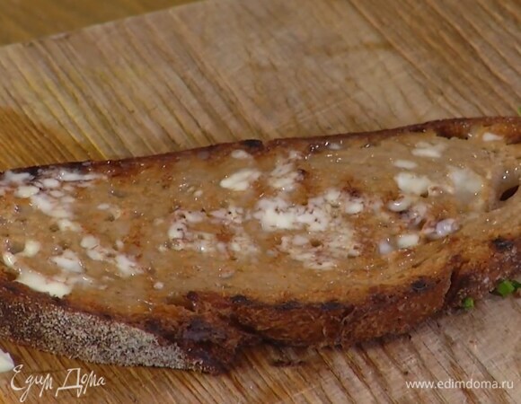 Разогреть сковороду-гриль и подсушивать хлеб с двух сторон до появления румяных полосок, затем смазать оставшимся сливочным маслом и нарезать полосками.