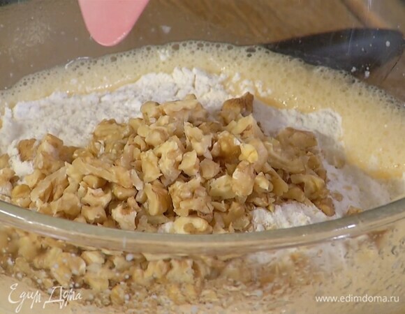 Всыпать муку, разрыхлитель, рубленые орехи и соль и вымешать тесто лопаткой.