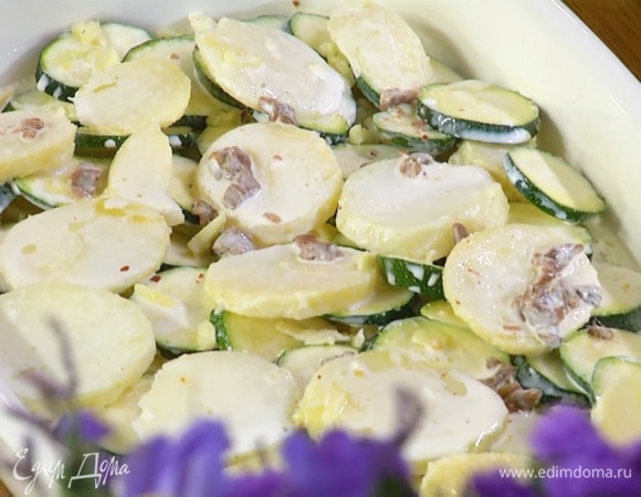 Сливки и молоко влить в сотейник, добавить анчоусы и прогревать все на огне до появления первых пузырьков, затем залить овощи в форме.