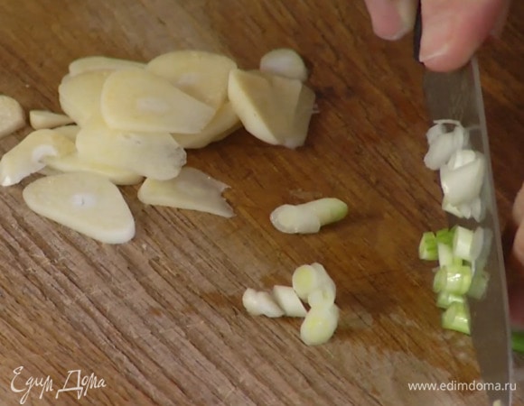 Зеленый лук тонко нарезать наискосок, отделив белую часть нарезанного лука от зеленой.