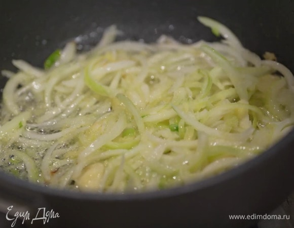 В глубокой тяжелой сковороде разогреть оставшееся растительное масло, выложить репчатый лук, чеснок, белую часть зеленого лука и натертый имбирь, все посолить, поперчить, перемешать и обжарить до прозрачности.