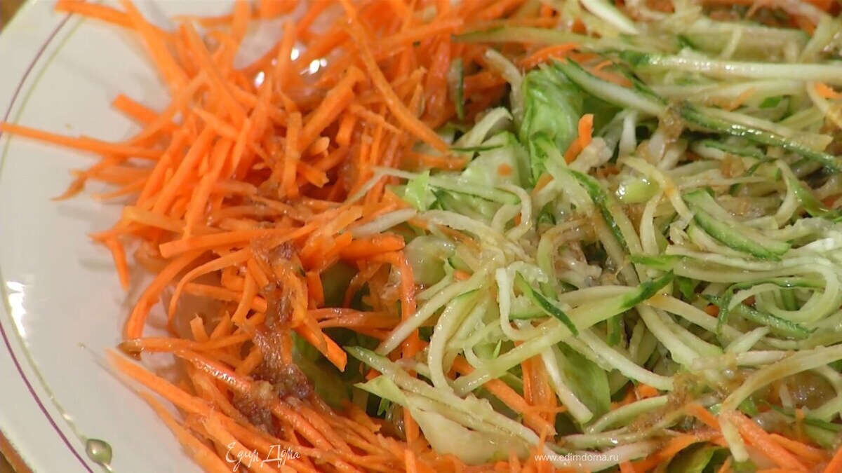 На большое блюдо выложить латук, на него по краям морковь, в центр огурцы, полить все заправкой.