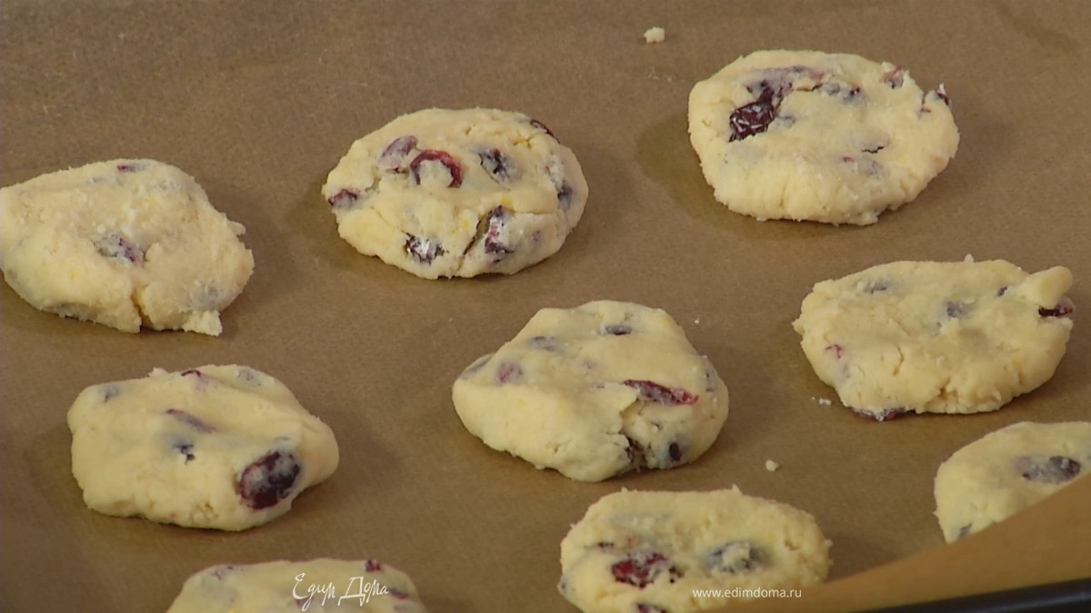 Сформировать из теста небольшие лепешки и выложить на противень, выстеленный бумагой для выпечки.