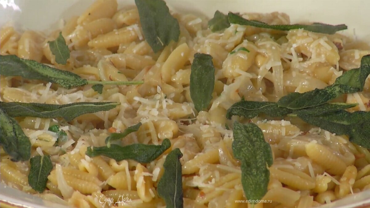 Готовые макароны посыпать фундуком и петрушкой, выложить в глубокое блюдо, посыпать оставшимся пармезаном и украсить обжаренными листьями шалфея.