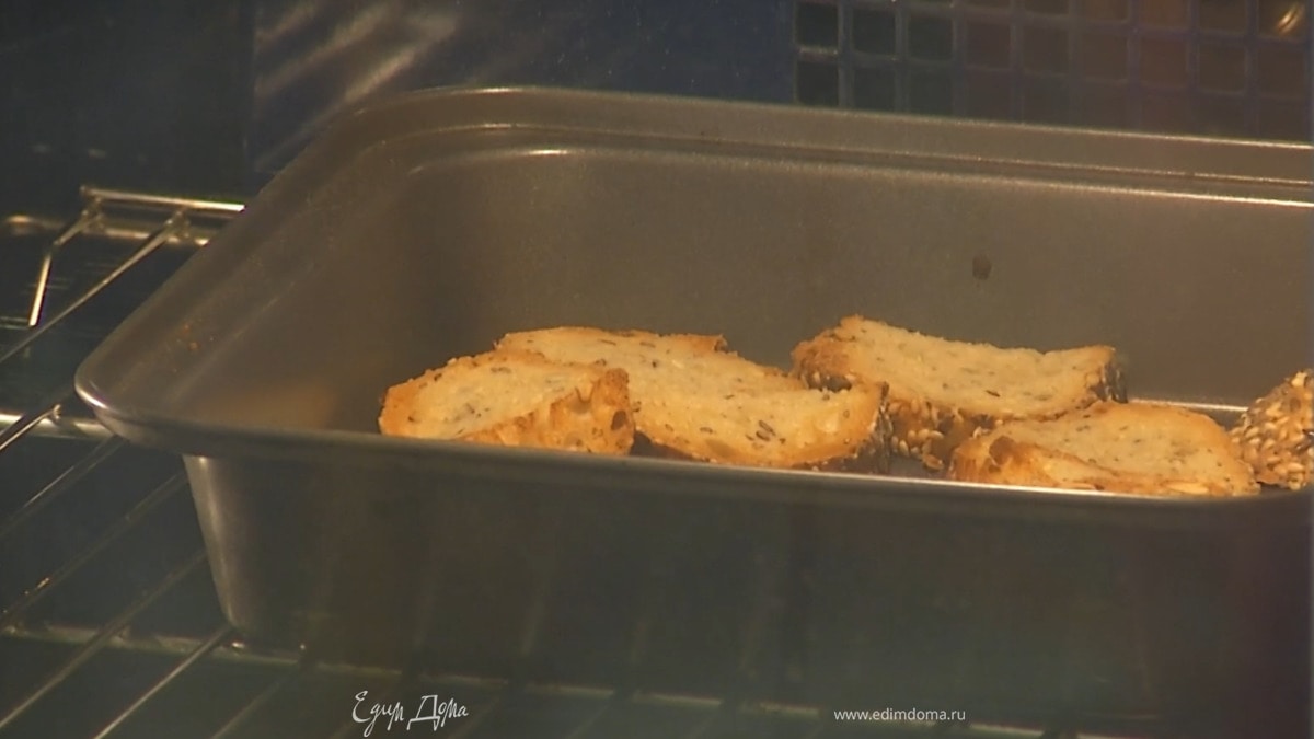 Хлеб нарезать небольшими кусочками, выложить в небольшой противень и запекать под разогретым грилем до появления румяной корочки.