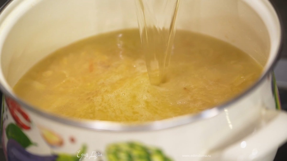 В кастрюлю с луком влить горячий куриный бульон, добавить лавровые листья, белый перец, посолить и варить еще 10 минут, затем лаврушку удалить.
