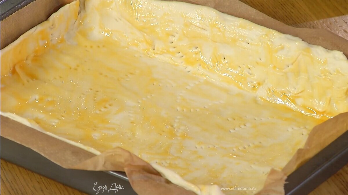 Сформировать из теста бортики, часто наколоть его вилкой и смазать яичным желтком с солью.