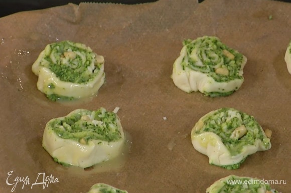 Яичный желток перемешать с молоком и солью и смазать кусочки теста.