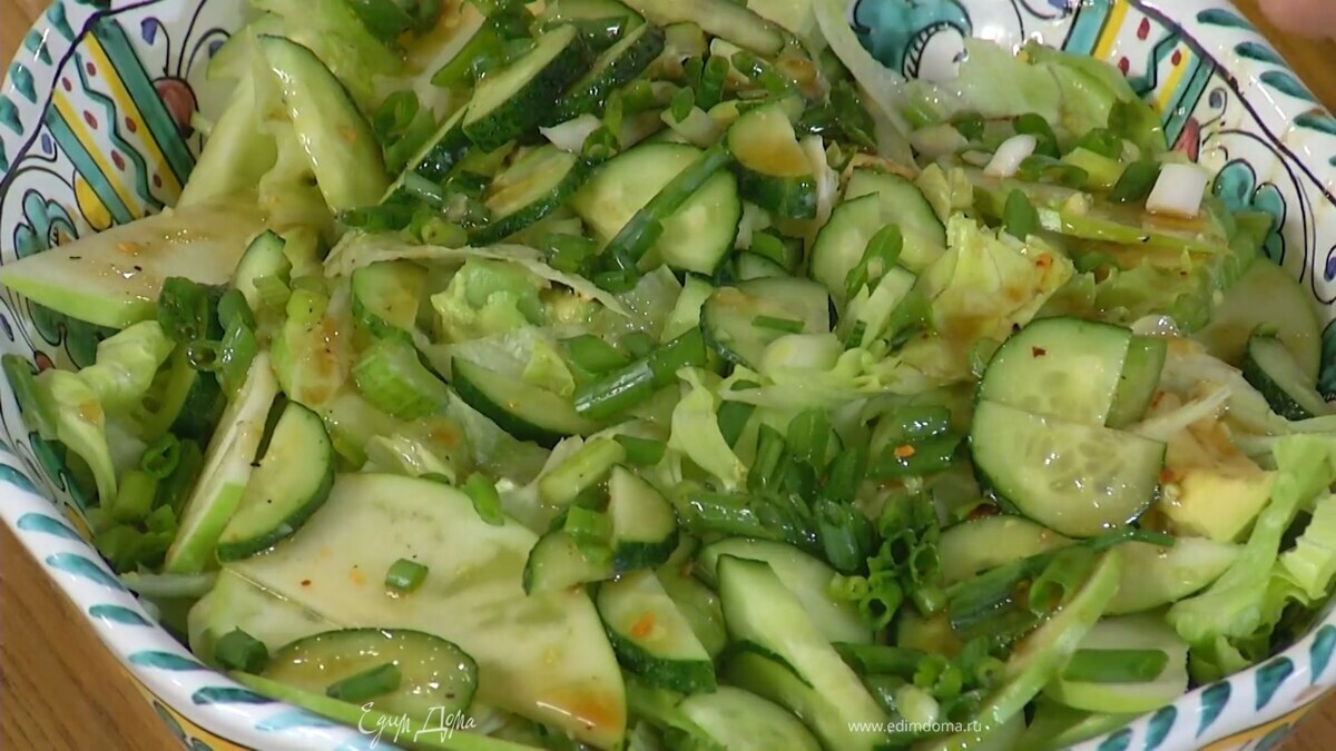 Зеленый лук тонко порезать наискосок, выложить в салат и полить все заправкой.