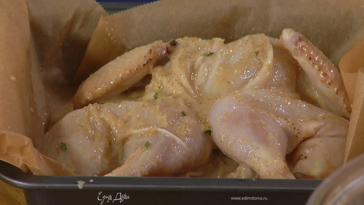 В небольшую форму, выстеленную бумагой для выпечки, выложить замаринованного цыпленка грудкой вверх и полить оставшимся маринадом.