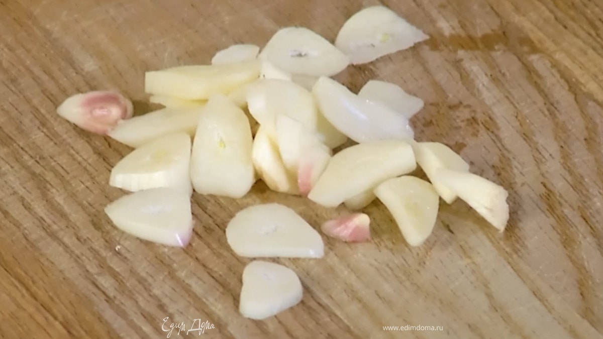 Чеснок почистить, нарезать пластинками, добавить в сковороду, слегка посолить, посыпать белым перцем и чили, все перемешать.