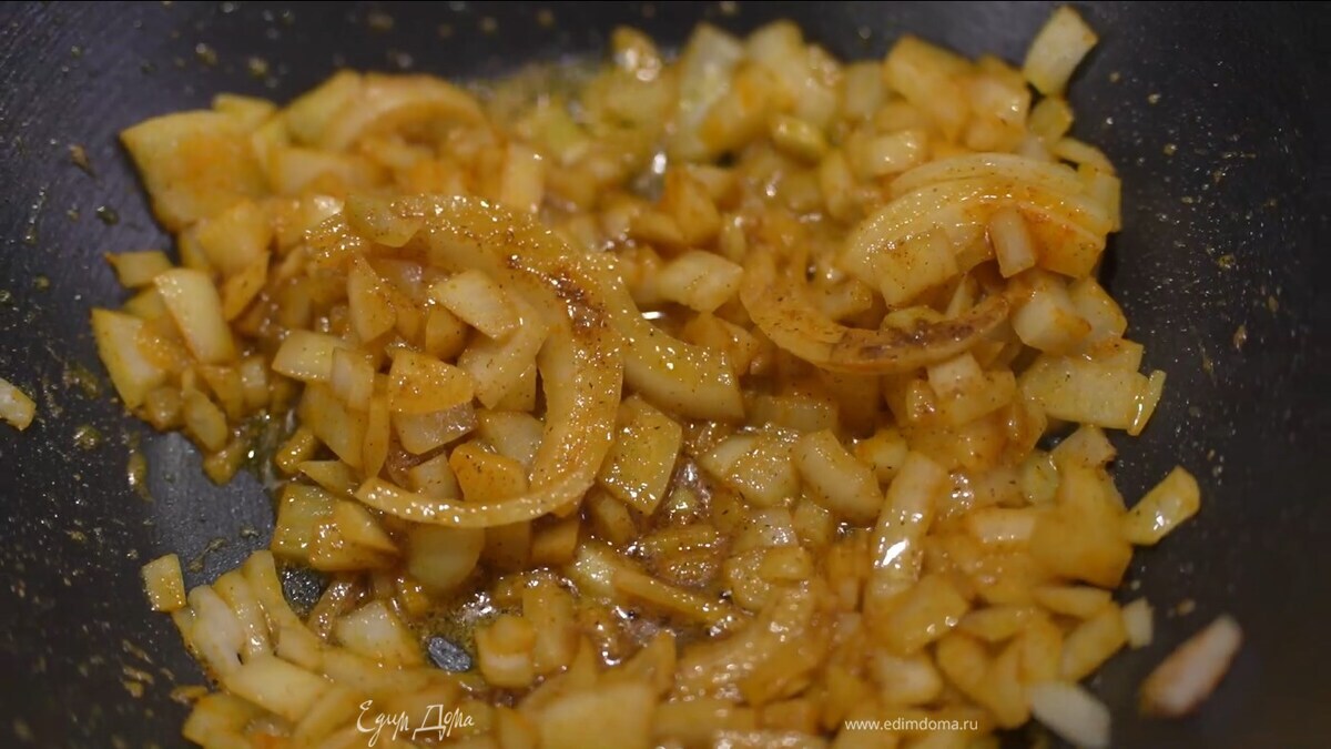 Разогреть в тяжелой глубокой сковороде половину оливкового масла, выложить лук, посыпать его куркумой и кориандром, слегка посолить, перемешать и обжарить.