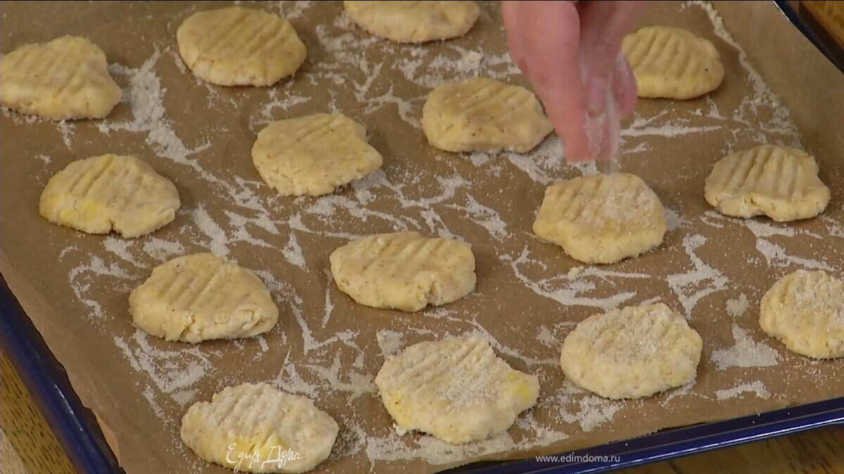 Влажными руками сформировать из теста небольшие лепешки и выложить на противень, вилкой прочертить на них полоски, сверху посыпать оставшимся сахаром.