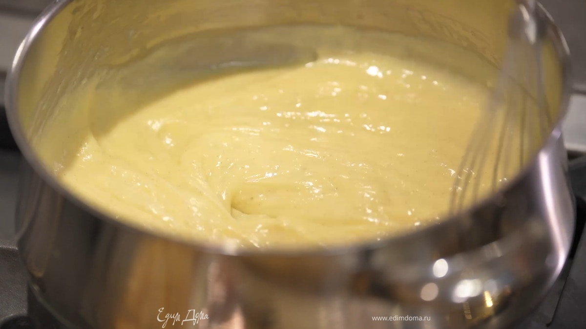 Оставшееся молоко влить в стакан для взбивания, добавить сахар, желтки, муку, крахмал и взбить все блендером с насадкой-венчиком, затем добавить в кастрюлю с горячим молоком и, непрерывно перемешивая, прогревать, пока крем не заварится. Выключить огонь и перемешивать еще некоторое время.