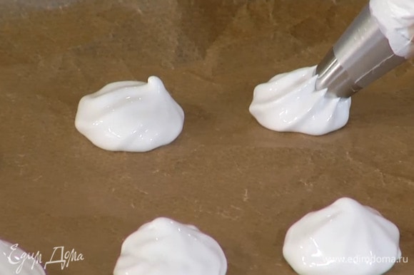 Взбитые белки выложить в кондитерский мешок и отсадить на противень небольшие лепешки.