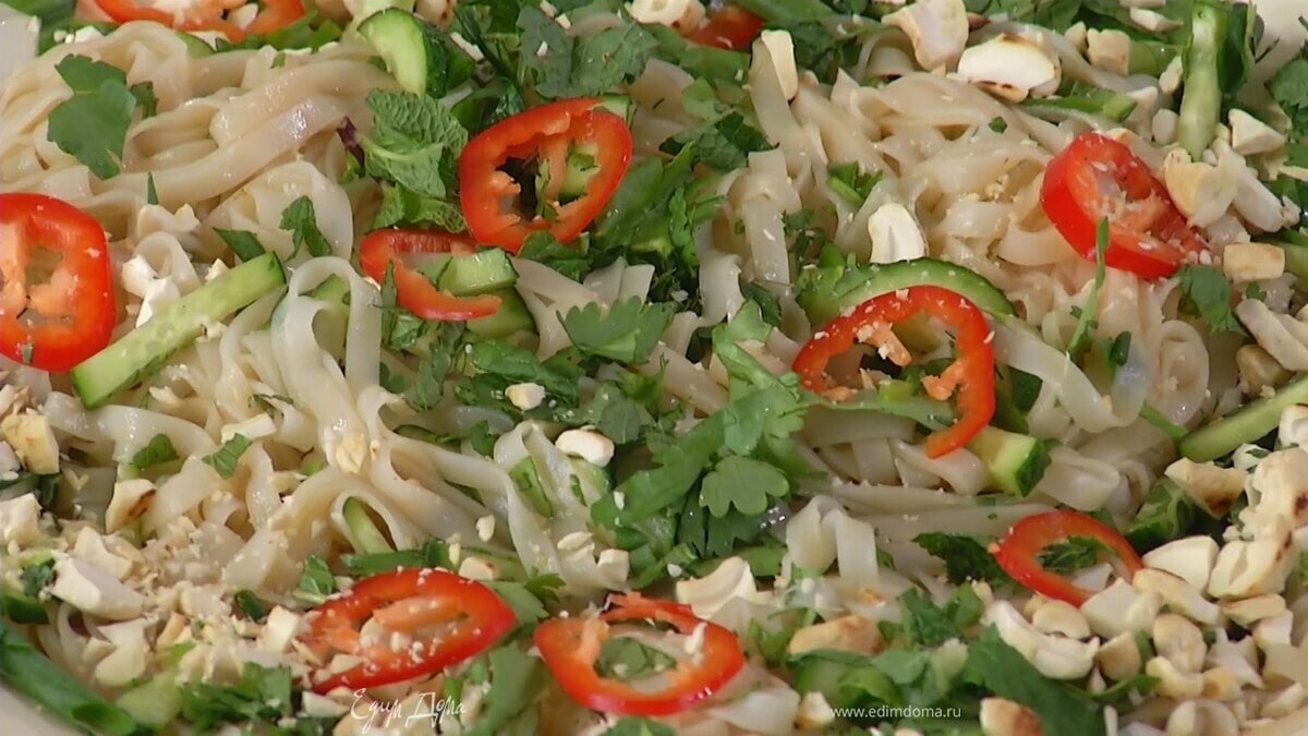 Отваренную лапшу выложить на тарелку, через сито полить соусом и выжатым из лайма соком, все перемешать, добавить огурец, измельченную зелень, перемешать еще раз, посыпать нарезанным чили и кешью.