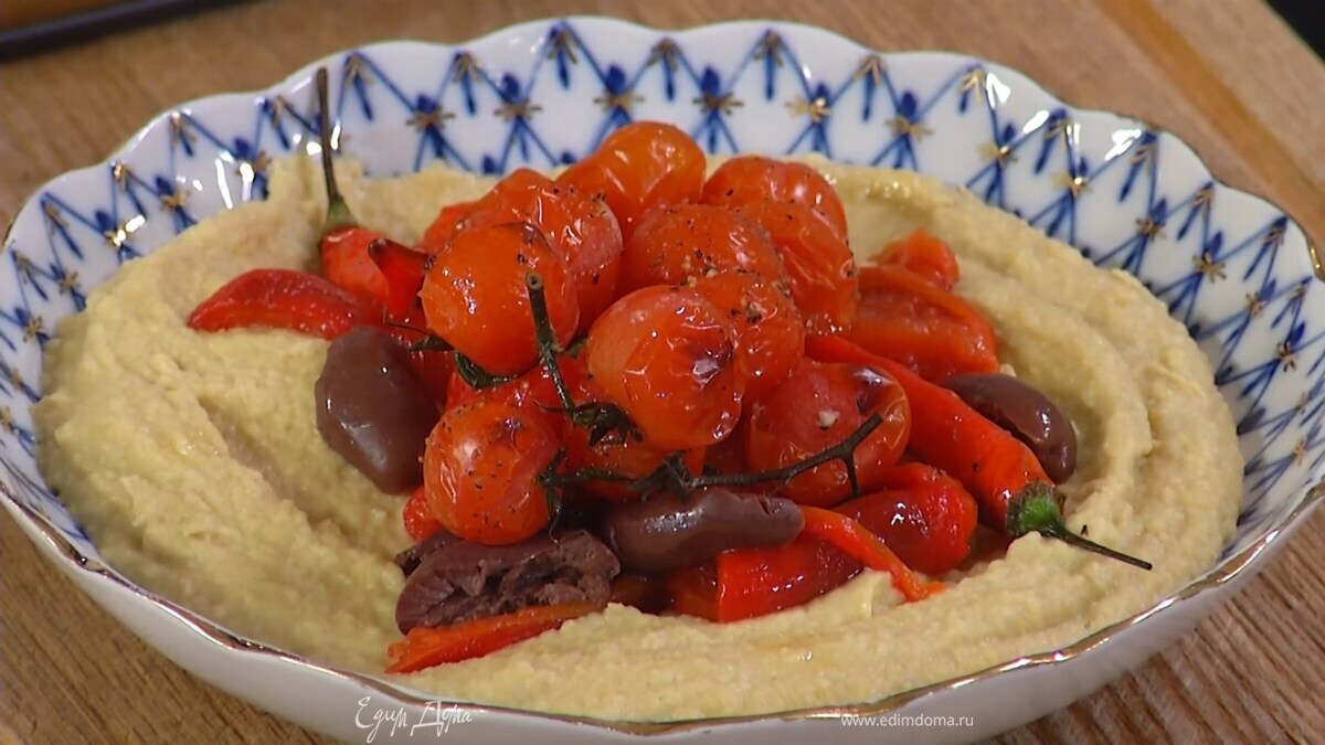 Выложить хумус в глубокую тарелку, сверху разложить оливки, запеченный перец, помидоры и чили, посыпать все оставшимися листьями тимьяна.