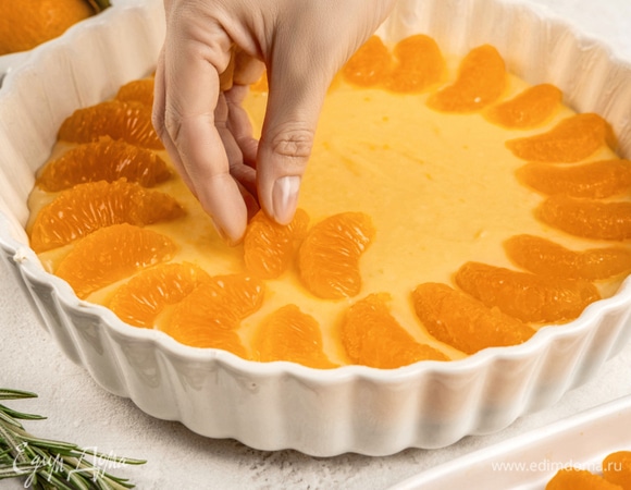 Смажьте форму 20–24 см маргарином. Выложите тесто, сверху положите дольки мандаринов, слегка вдавливая их в тесто.