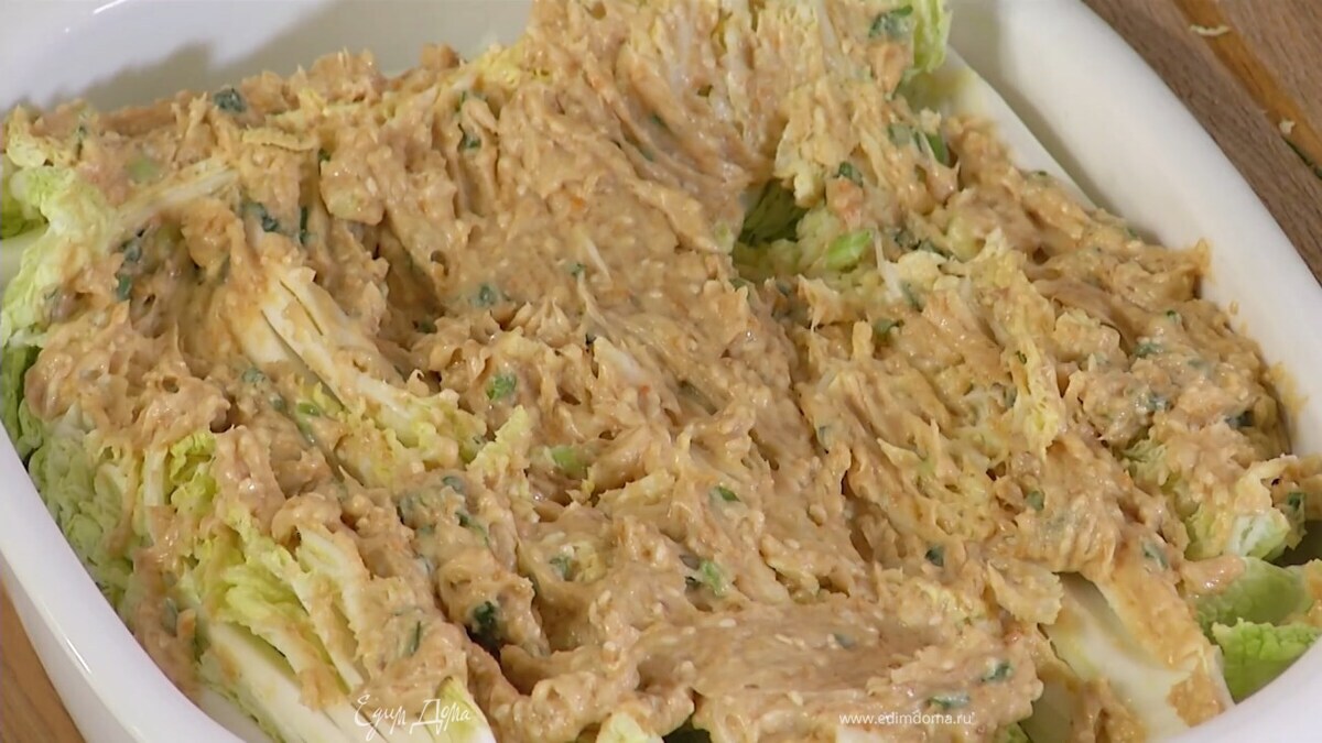 Пекинскую капусту нарезать вдоль на 8 частей, выложить в жаропрочную керамическую форму и смазать заправкой.