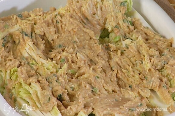 Пекинскую капусту нарезать вдоль на 8 частей, выложить в жаропрочную керамическую форму и смазать заправкой.