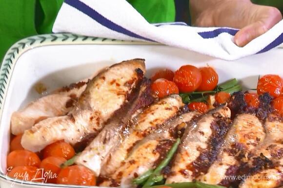 В керамическую жаропрочную форму выложить помидоры, фасоль и рыбу, сверху разложить чесночную массу, сбрызнуть все оставшимся оливковым маслом и запекать в разогретой духовке 15–20 минут.