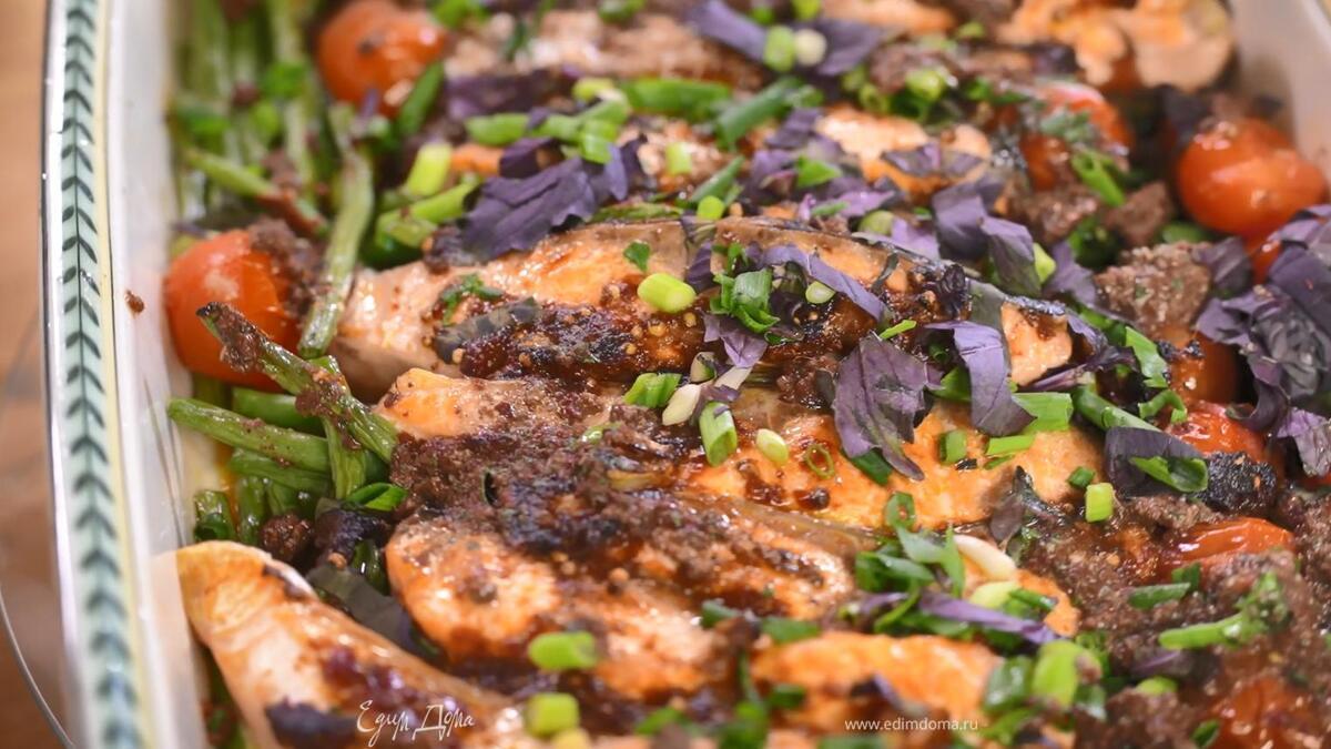 Запеченную рыбу с овощами посыпать измельченной зеленью, сверху разложить тапенад.