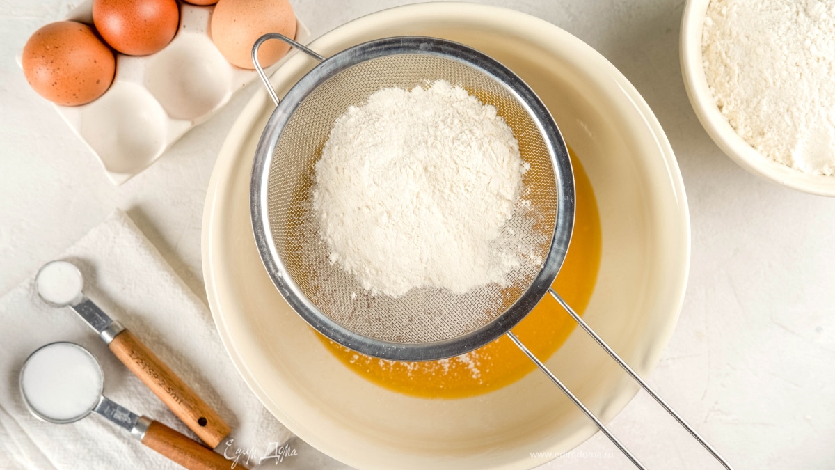 Добавьте просеянную муку и соду. Замесите тесто до однородного состояния.