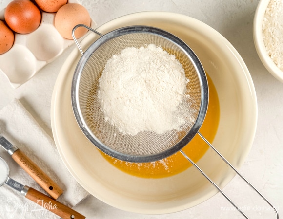 Добавьте просеянную муку и соду. Замесите тесто до однородного состояния.