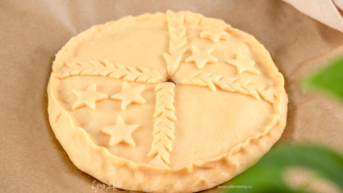 Сформируйте фигурки из остатков теста: сделайте на полосках теста боковые надрезы и положите их сверху. Вырежьте снежинки с помощью формы и также добавьте сверху.