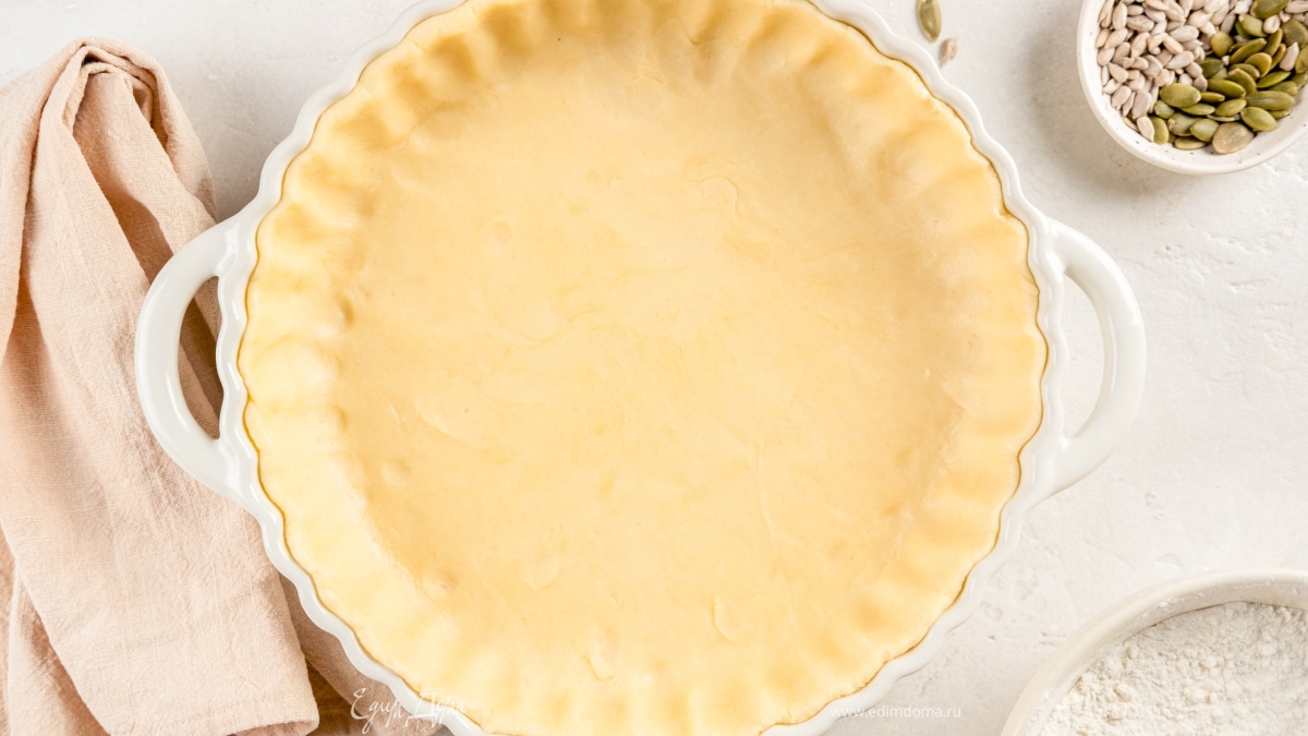 Раскатайте тесто в тонкий пласт и выложите его в форму, застеленную пергаментом. Сформируйте бортики. Поставьте в морозилку на 20 минут.