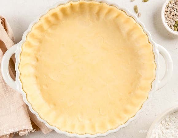 Раскатайте тесто в тонкий пласт и выложите его в форму, застеленную пергаментом. Сформируйте бортики. Поставьте в морозилку на 20 минут.