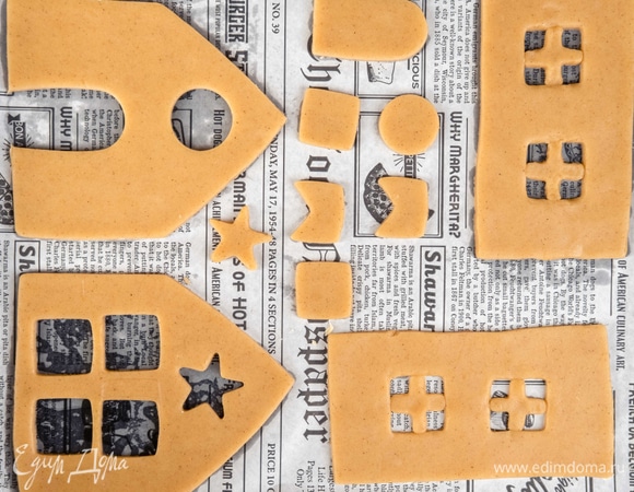 Вырежьте детали домика по шаблонам из бумаги. Перенесите детали на противень с пергаментом. Вырежьте окна и двери по желанию. Выпекайте при 180°C 8–12 минут до слегка золотистого цвета.