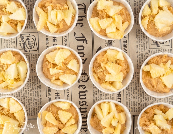 Переложите тесто в формы. Сверху положите яблоки и вдавите их в тесто.