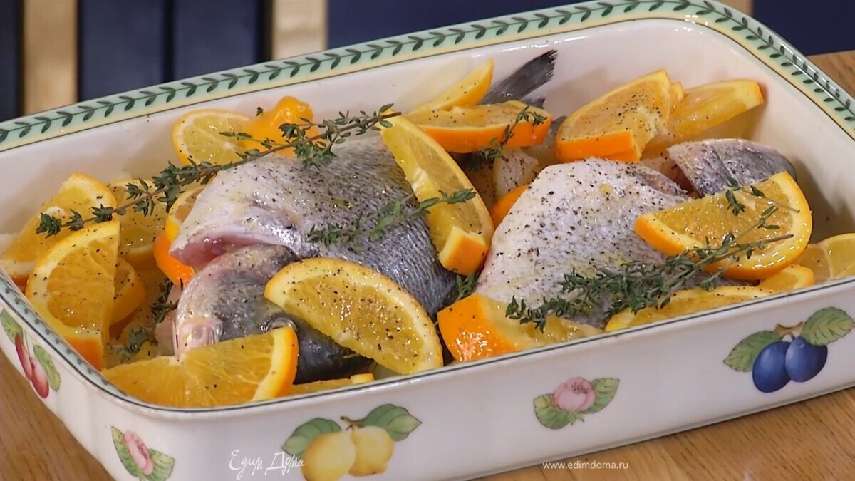 Часть цитрусовых вложить в брюшки дорады, сверху разложить лук и оставшийся апельсин с лимоном, полить все оставшимся оливковым маслом, еще раз посолить, поперчить, выложить веточки тимьяна.