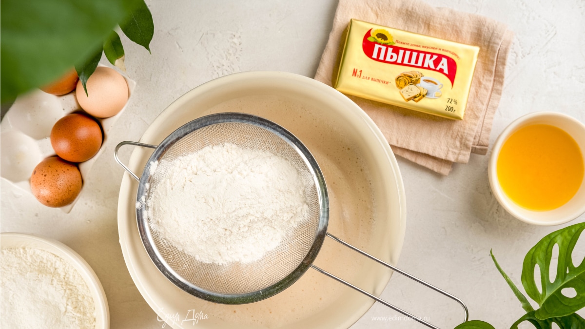 Влейте в миску оставшееся молоко, добавьте яйца и дрожжи. Всыпьте 250 г муки и размешайте.