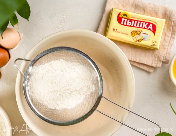 Влейте в миску оставшееся молоко, добавьте яйца и дрожжи. Всыпьте 250 г муки и размешайте.