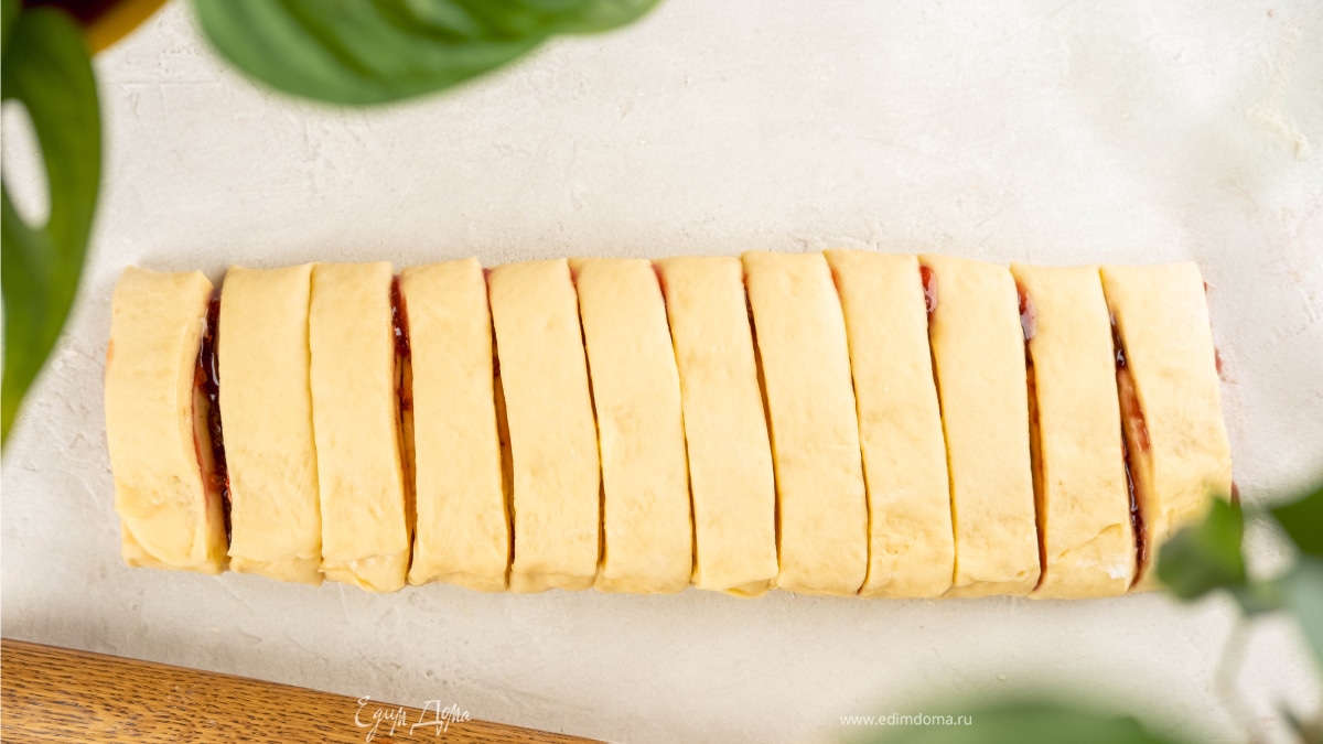 Разрежьте тесто поперек на 12 частей шириной 2,5 см. Перекрутите каждую часть 3–4 раза и сложите колечком, соедините концы.