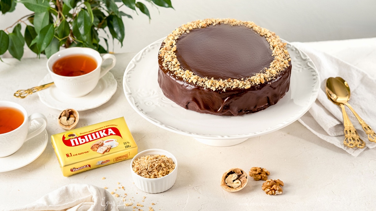 Полейте бисквит глазурью и украсьте его грецкими орехами.