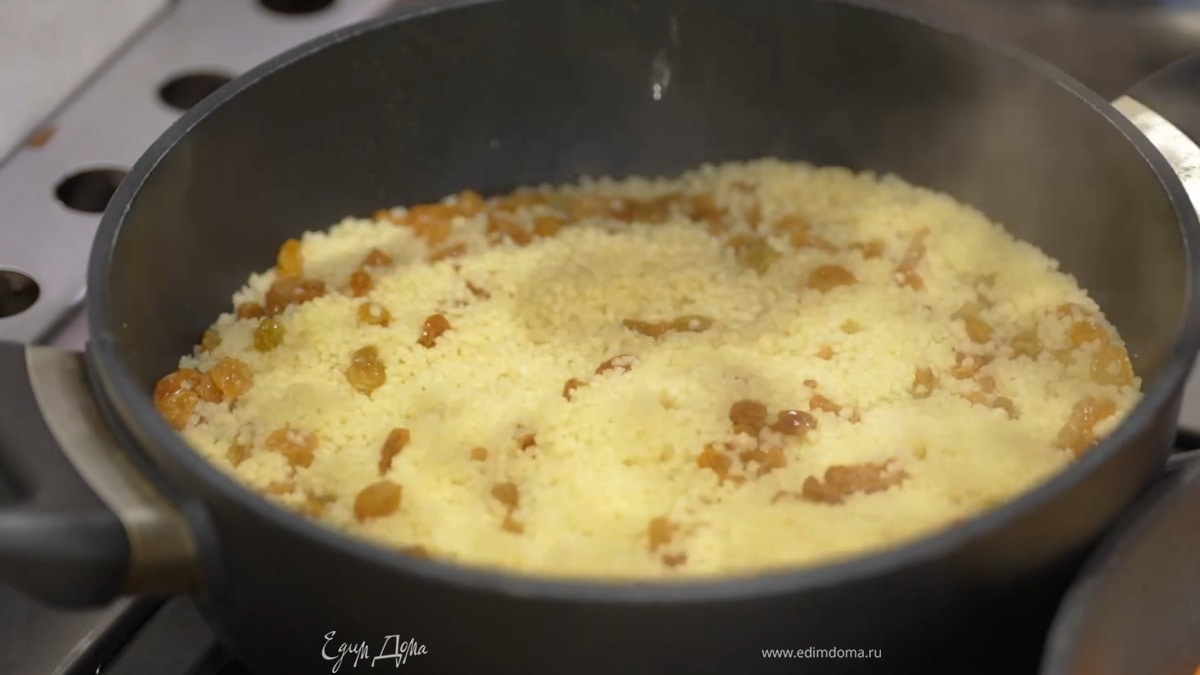 Разогреть в тяжелом сотейнике 2 ст. ложки оливкового масла, всыпать кускус и обжарить до золотистого цвета, затем добавить изюм, уменьшить огонь и влить горячий бульон, так чтобы кускус был на сантиметр покрыт жидкостью, слегка посолить, накрыть крышкой и томить до готовности.