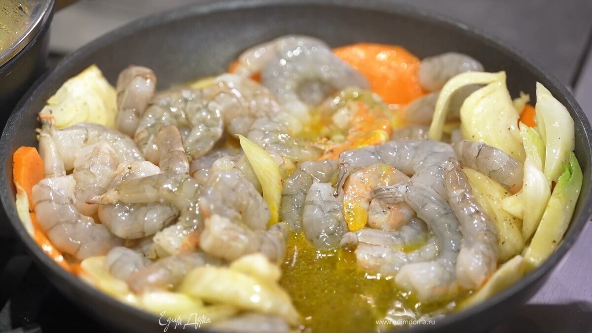 В отдельной сковороде разогреть оставшееся оливковое масло, выложить подготовленные овощи, посыпать их паприкой, солью и перцем и обжарить до золотистого цвета, затем добавить креветки, влить замоченный шафран, белое вино, перемешать и довести до готовности.