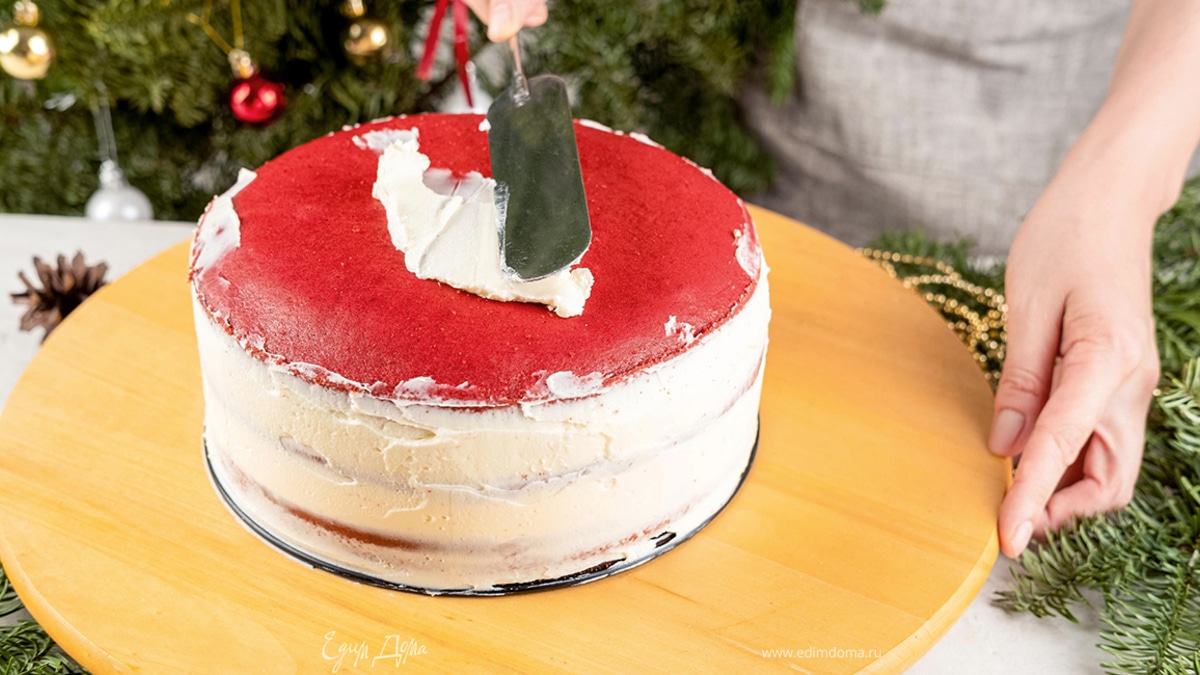 Соберите торт: положите корж срезанной верхушкой вверх. Распределите ⅓ крема по поверхности торта. Повторите с оставшимися коржами, смазывая промежутки кремом. Смажьте бока и поверхность торта оставшимся кремом.