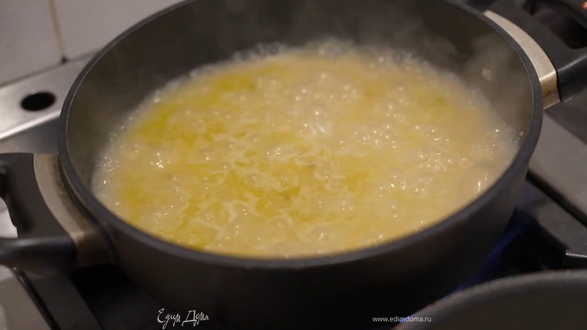 Разогреть в глубоком сотейнике оливковое масло и обжарить лук до прозрачности, затем всыпать рис, все перемешать, залить горячим бульоном, так чтобы жидкость была на пару сантиметров выше риса, и томить до готовности.