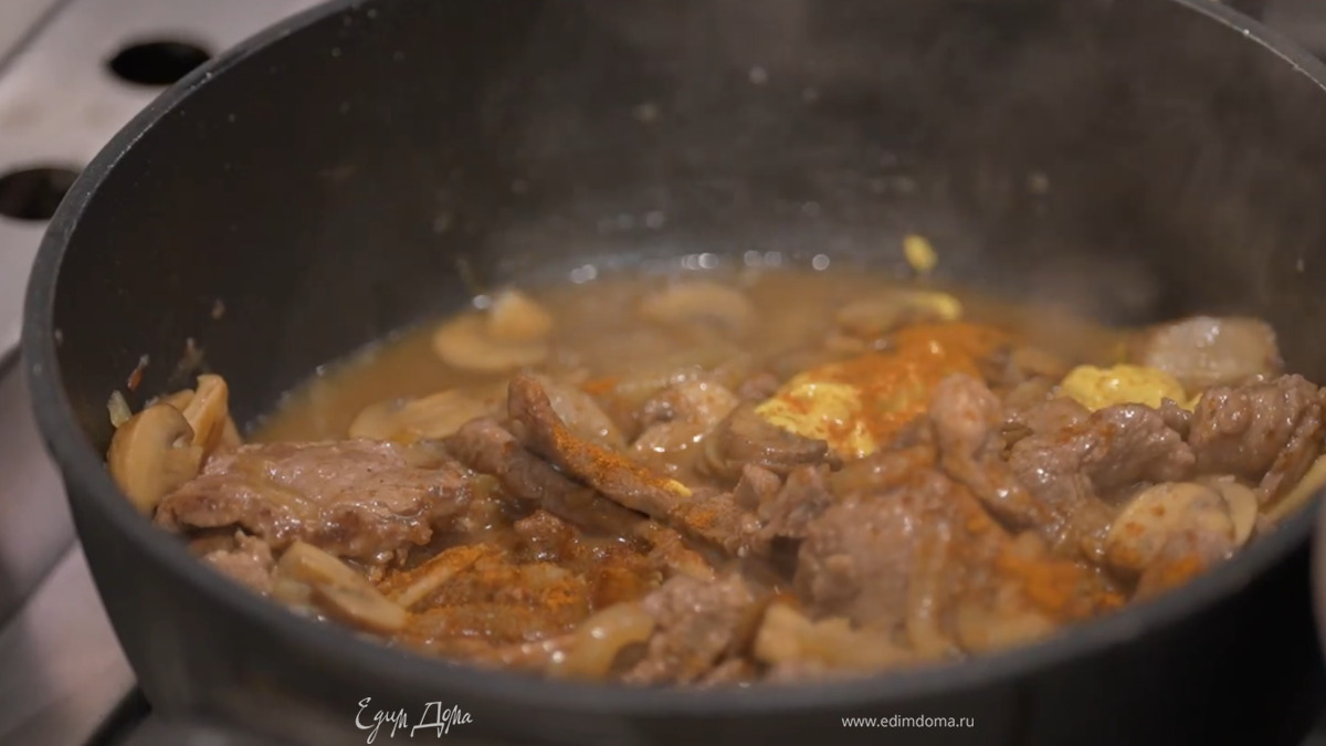 Вино влить к мясу, выложить грибы, посолить, перемешать, накрыть крышкой и готовить 10 минут, затем добавить горчицу, паприку, перемешать и продолжить томить под крышкой.