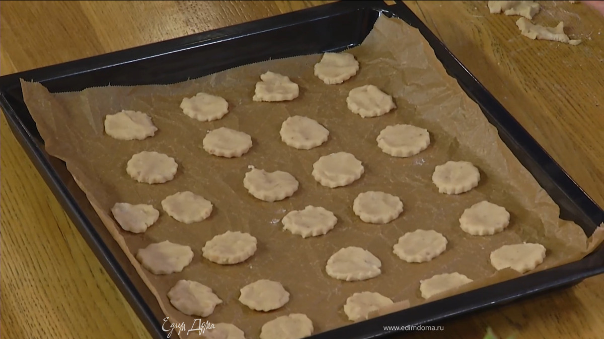Формочкой вырезать из теста печенье и выложить на противень, выстеленный бумагой для выпечки.