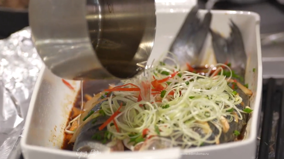 Вынуть рыбу из духовки, выложить на нее весь лук и сладкий перец, полить сверху разогретым растительным маслом.