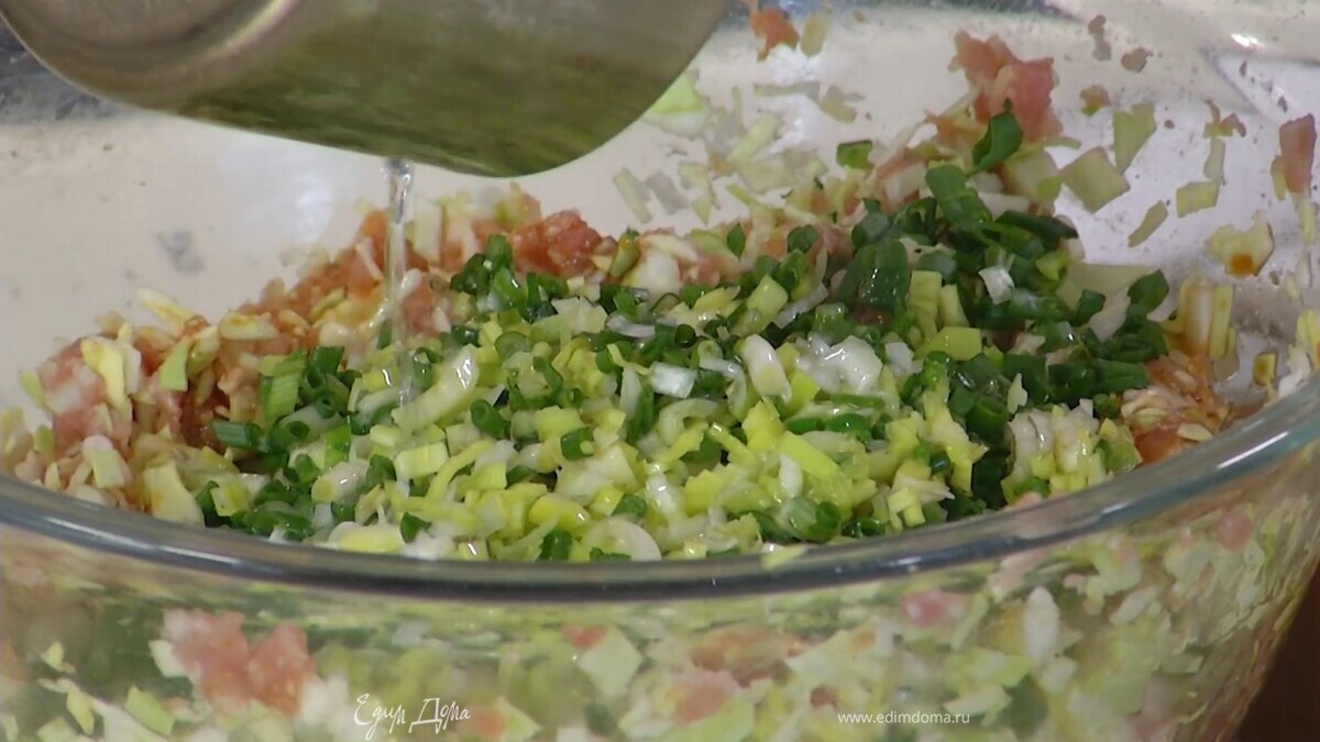 Капусту слегка помять руками, добавить в фарш и перемешать, затем добавить измельченный зеленый лук и порей, полить 1 ст. ложкой кунжутного масла и все перемешать.